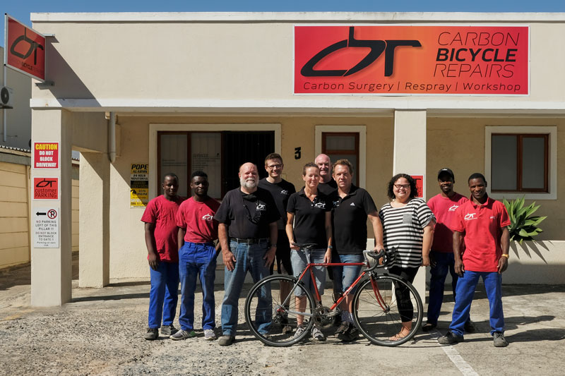Carbon bicycle repair team in front of the shop